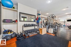 Dedicated fitness area featuring recessed lighting and a large framed mirror - 