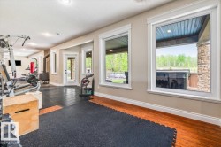 Dedicated interior space featuring large windows, a wood-finish floor, recessed lighting, and direct exterior access - 