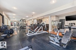 Dedicated fitness space featuring rubber flooring, recessed lighting, and a built-in wet bar with pendant lighting - 