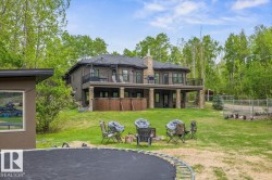 Two-story residential structure featuring a lower-level covered patio and an upper-level balcony with metal railings - 