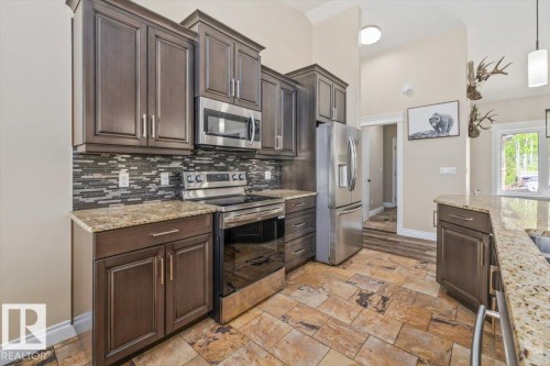 Kitchen featuring dark wood cabinetry, granite countertops, and a full suite of stainless steel appliances - #6 2406 Twp Road 540, Rural Lac Ste. Anne County, AB - Indoor Photo Showing Kitchen With Upgraded Kitchen