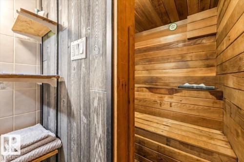 Interior sauna featuring multi-level wood benches, wood-paneled walls, and a wood-finish ceiling - 11603 70 Street Nw, Edmonton, AB 