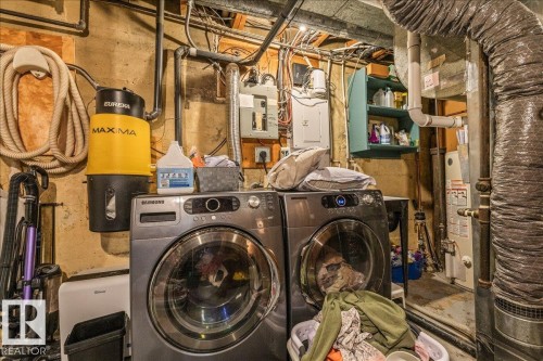 Laundry area featuring a side-by-side washer and dryer, built-in wall shelving, and utility hookups - 11603 70 Street Nw, Edmonton, AB 