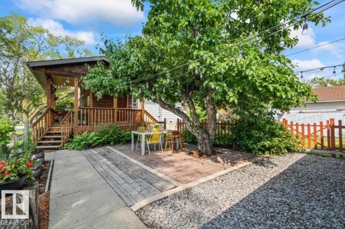 Expansive outdoor living area featuring a wood-plank deck, wood railings, and a covered porch - 11603 70 Street Nw, Edmonton, AB 