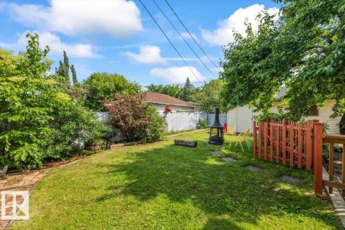 Expansive backyard featuring a green lawn, mature trees, and a brick pathway - 11603 70 Street Nw, Edmonton, AB 