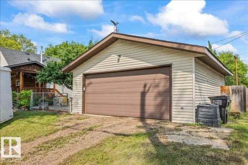 Detached garage with horizontal siding, a brown panel garage door, and a brown shingle roof - 11603 70 Street Nw, Edmonton, AB 