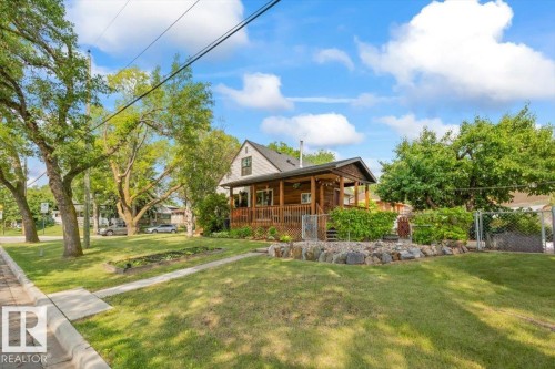 Two-story residence featuring a wood-sided exterior and a covered front porch - 11603 70 Street Nw, Edmonton, AB 