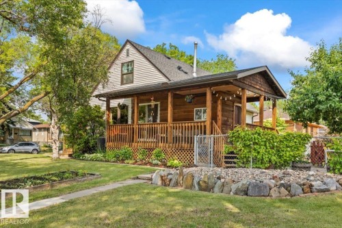 Front exterior featuring a covered wood deck, horizontal siding, and a gabled roof - 11603 70 Street Nw, Edmonton, AB 