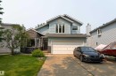 Two-story residence featuring light blue siding, stone veneer accents, and a dual-pane garage door - 14 Durand Place, St. Albert, AB 