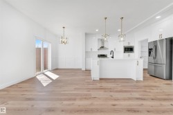 Open-concept kitchen and living area featuring wood-finish flooring - 