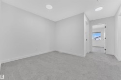 Carpeted room featuring recessed lighting, white walls, and white baseboards - 