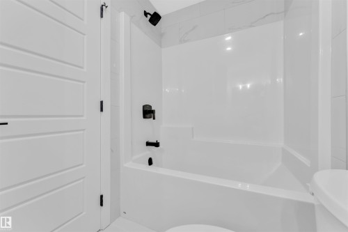 White bathtub-shower combination with matte black fixtures - 523 Kleins Court, Leduc, AB - Indoor Photo Showing Bathroom