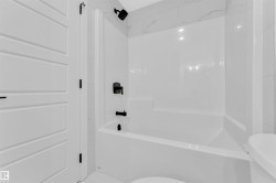 White bathtub-shower combination with matte black fixtures - 