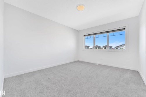 Bright room featuring a large window with white framing and integrated blinds - 523 Kleins Court, Leduc, AB - Indoor Photo Showing Other Room