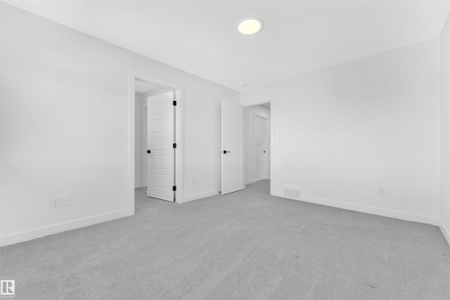 Neutral gray carpeting complements bright white walls and trim - 523 Kleins Court, Leduc, AB - Indoor Photo Showing Other Room