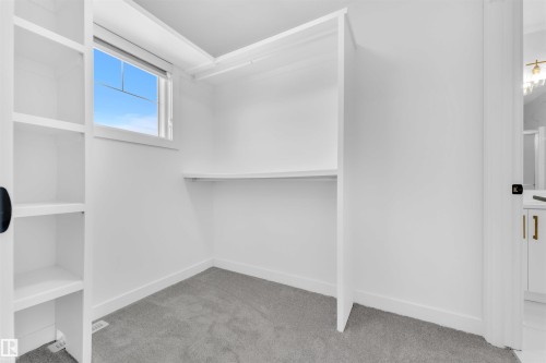 White built-in shelving and closet system with a window providing natural light - 523 Kleins Court, Leduc, AB - Indoor