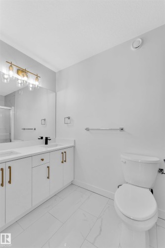 Modern bathroom featuring a dual vanity with white cabinetry and gold-tone hardware - 523 Kleins Court, Leduc, AB - Indoor Photo Showing Bathroom