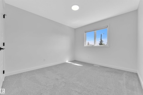 Bright room featuring a large window, plush gray carpeting, white baseboards, and a contemporary flush-mount ceiling light fixture - 523 Kleins Court, Leduc, AB - Indoor Photo Showing Other Room