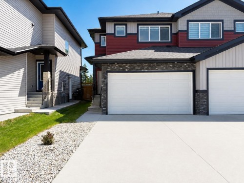Modern residential facade featuring contrasting red and grey siding with black trim - 523 Kleins Court, Leduc, AB - Outdoor