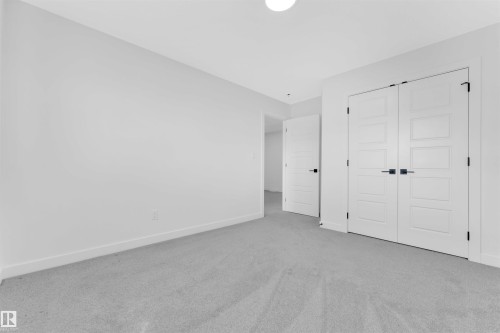 Light gray carpeting extends throughout this room, featuring white walls and baseboards - 523 Kleins Court, Leduc, AB - Indoor Photo Showing Other Room