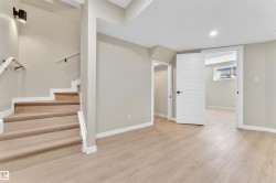 Light wood-finish flooring extends throughout this finished space, complemented by neutral wall tones - 