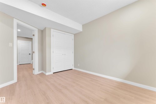 Light wood-finish flooring and neutral wall tones define this room, featuring white baseboards and trim - 523 Kleins Court, Leduc, AB - Indoor Photo Showing Other Room