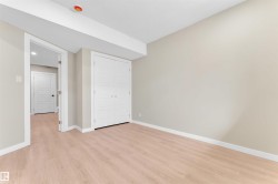 Light wood-finish flooring and neutral wall tones define this room, featuring white baseboards and trim - 