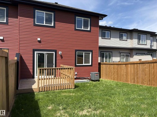 Private backyard featuring a wooden deck, sliding glass door access, and a full perimeter wood fence - 523 Kleins Court, Leduc, AB - Outdoor With Exterior