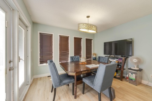 Dining space featuring light wood-finish flooring, light blue wall paint, and a decorative pendant light fixture - 17328 106 Street, Edmonton, AB 