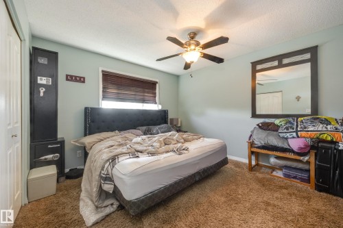 Bedroom featuring wall-to-wall carpeting, light blue wall paint, and a ceiling fan with integrated lighting - 17328 106 Street, Edmonton, AB 