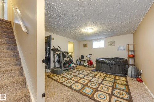 Carpeted lower level room featuring recessed lighting and a textured ceiling - 17328 106 Street, Edmonton, AB 