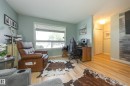 Light-toned wood-finish flooring complements the pale blue wall color in this versatile room - 17328 106 Street, Edmonton, AB 