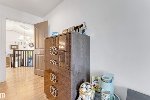Light wood-finish flooring extending into an open doorway - 7920 7 Avenue, Edmonton, AB 