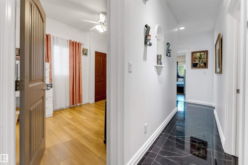 Hallway featuring polished black marble-look flooring with white veining - 7920 7 Avenue, Edmonton, AB 
