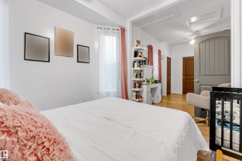 Light-filled interior featuring a bay window, hardwood-finish flooring, and white walls - 7920 7 Avenue, Edmonton, AB 