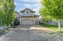 Two-story home featuring a front-facing garage, arched window, and a concrete driveway - 7920 7 Avenue, Edmonton, AB 