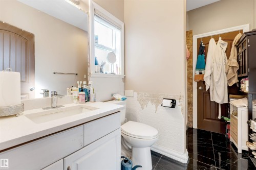 White vanity with an integrated sink and countertop, complemented by a modern chrome faucet - 7920 7 Avenue, Edmonton, AB 