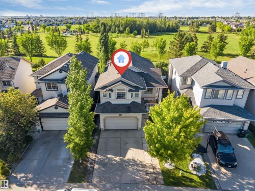 Two-story residence with an attached double garage, light-toned exterior siding, multiple windows, and a dark shingled roof - 7920 7 Avenue, Edmonton, AB 
