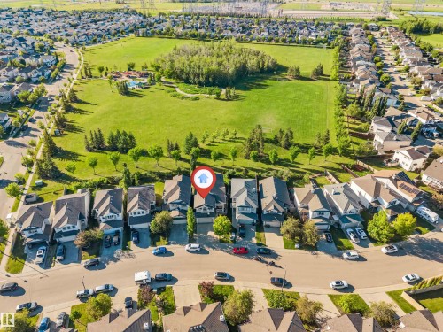 Aerial perspective of a residential street with detached homes, featuring a prominent large green space - 7920 7 Avenue, Edmonton, AB 