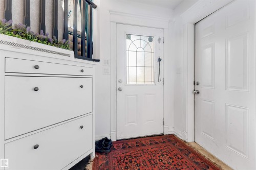 Entryway featuring a decorative glass panel door and a paneled interior door - 7920 7 Avenue, Edmonton, AB 