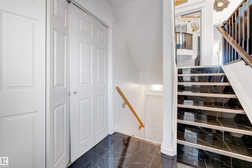Entryway featuring black marble-look floor tiles and a staircase with matching risers - 7920 7 Avenue, Edmonton, AB 