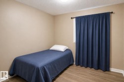 Room featuring light wood-finish flooring, neutral wall paint, and a window with a dark curtain rod - 