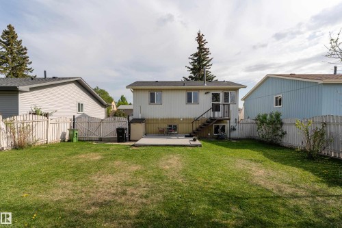 Expansive backyard featuring a large green space, a concrete patio, and a staircase providing direct access to the upper level - 4620 37A Avenue, Edmonton, AB - Outdoor With Exterior