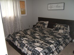 Bedroom featuring light gray walls, an integrated wood-finish headboard, and wall-to-wall carpeting - 
