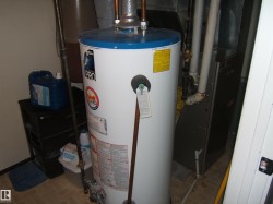 Dedicated utility area featuring a water heater and furnace unit - 