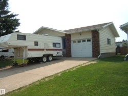Ranch-style exterior with attached garage, brick accents, and light-colored siding - 