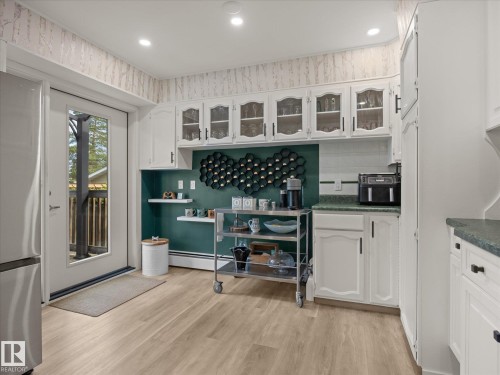 Kitchen area featuring light wood-finish flooring and white cabinetry - 8822 161 Street, Edmonton, AB 