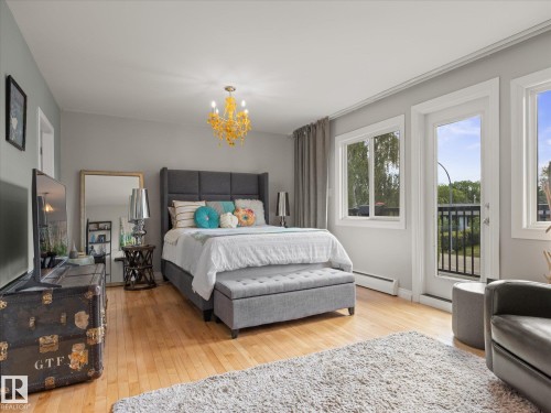 Hardwood-style flooring throughout this space with a built-in chandelier light fixture - 8822 161 Street, Edmonton, AB 