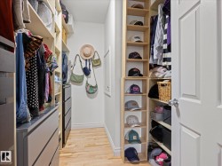 Custom closet organization system featuring light wood-finish flooring - 