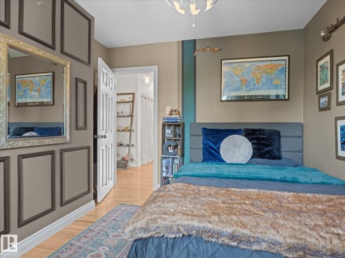 Bedroom with hardwood-style flooring and accent wall paneling - 8822 161 Street, Edmonton, AB 